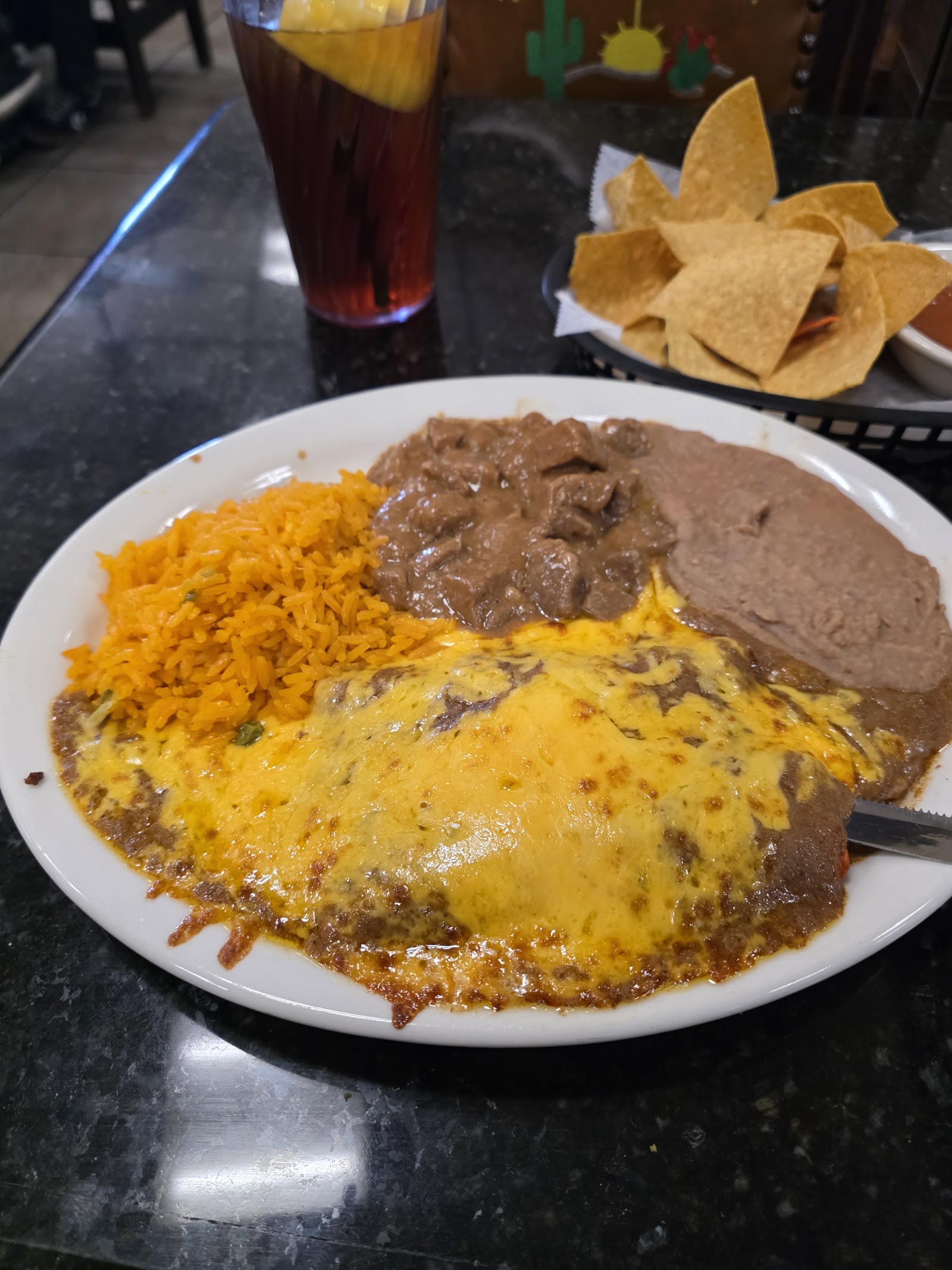 Cheese enchiladas plate with beef tips, rice, and beans